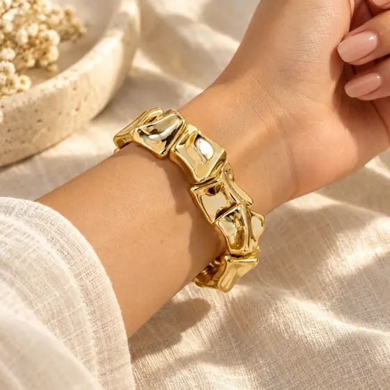 Gold-tone irregular geometric CCB bead bracelet · Wrist and reflective finish detail