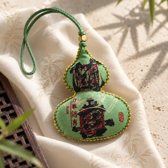 Green gourd sachet with gold stitching · Green sachet product image